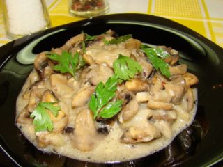 Stekte champignoner med løk og rømme: hvordan lage mat i en panne, i en langsom komfyr, soppsaus, saus